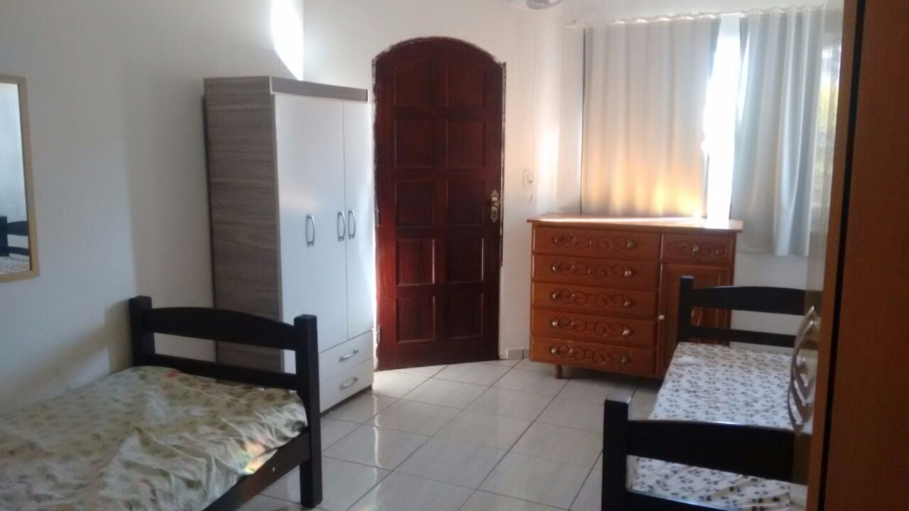 Quarto duplo com duas camas, guarda-roupa e cômoda