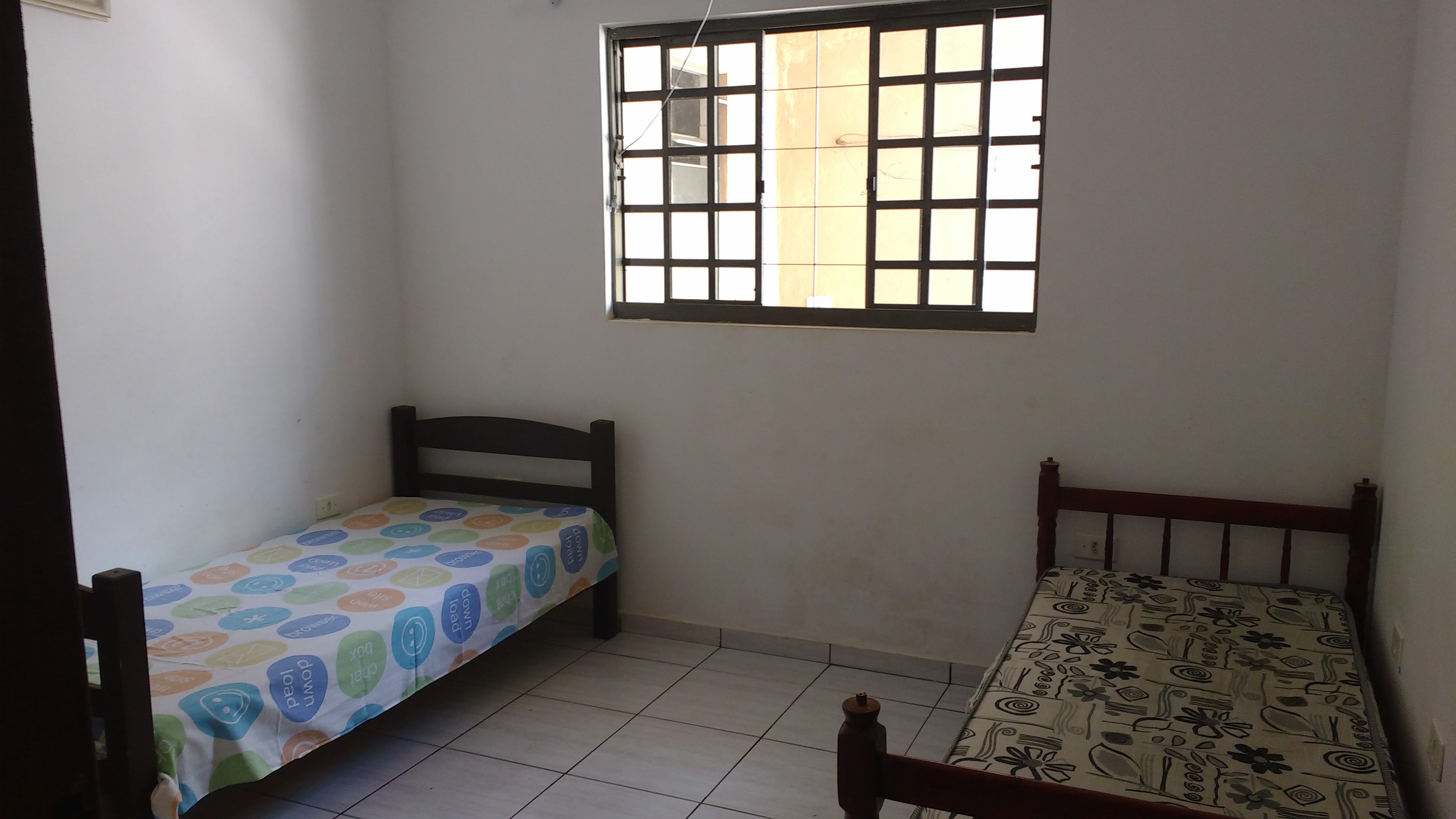 Quarto duplo com duas camas e janela ampla