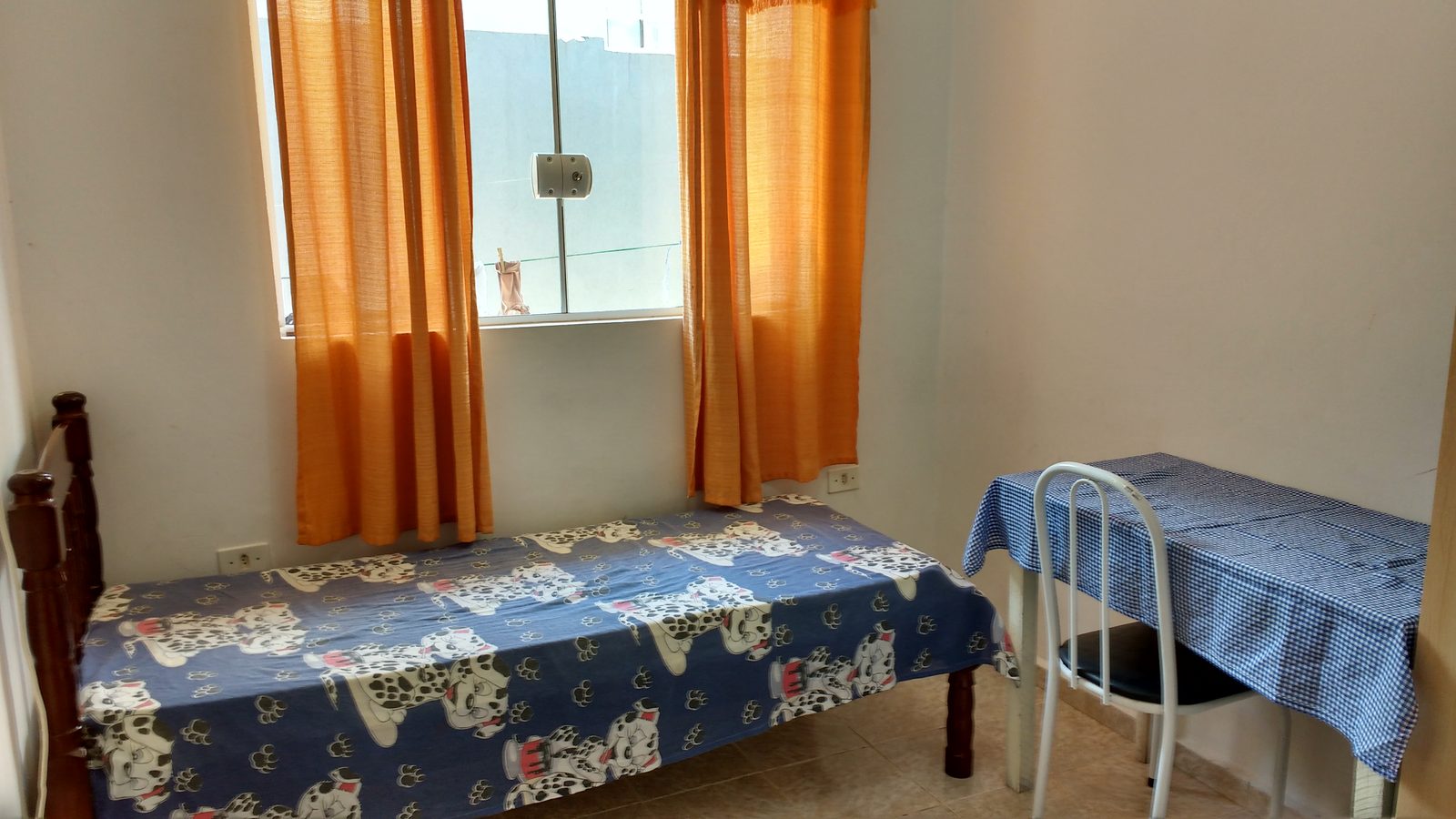 Quarto individual com cama, mesa e janela